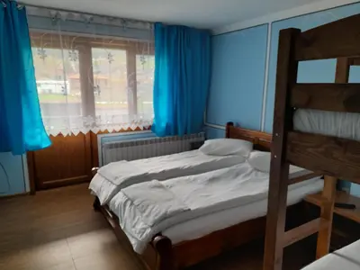 a bedroom with two bunk beds and a window at Къща Ради in Koprivshtitsa
