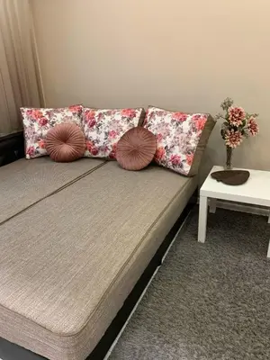 a couch with pillows on it in a living room at Harmony Centrally Located Studio in Sofia