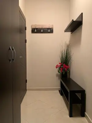 a hallway with a door and a table and flowers at Harmony Centrally Located Studio in Sofia