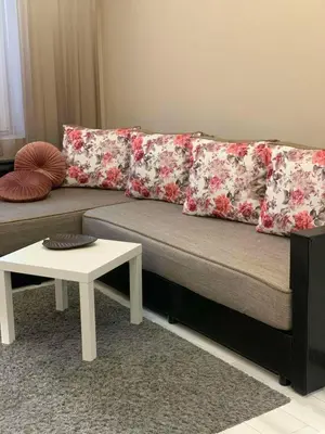 a couch with red and white pillows and a table at Harmony Centrally Located Studio in Sofia