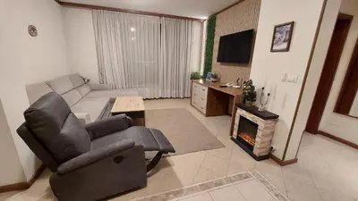 a living room with a couch and a chair and a fireplace at Free SPA в Св. Иван Рилски - Сладък дом сред лукс in Bansko