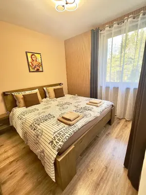 a bedroom with a large bed with a window at Petkovi Аpartments, Borovets Gardens - One-bedroom and Two-bedroom apartments in Borovets