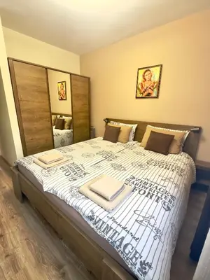 a bedroom with a large bed with towels on it at Petkovi Аpartments, Borovets Gardens - One-bedroom and Two-bedroom apartments in Borovets