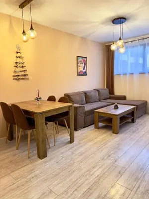 a living room with a couch and a table at Petkovi Аpartments, Borovets Gardens - One-bedroom and Two-bedroom apartments in Borovets