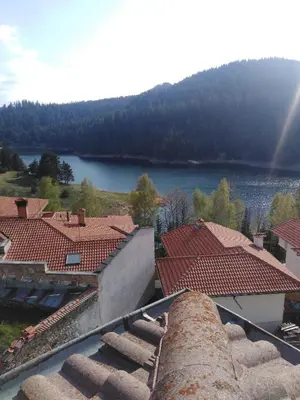 a view of a lake from a building with roofs at Вила Родопи in Dospat