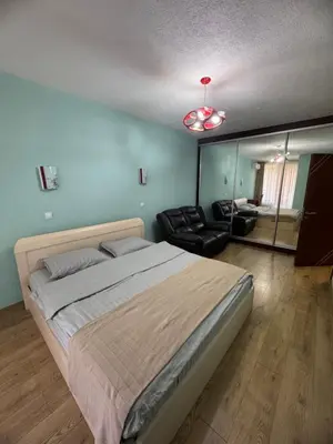 a bedroom with a large bed and a living room at Луксозен апартамент в сърцето на Сандански in Sandanski