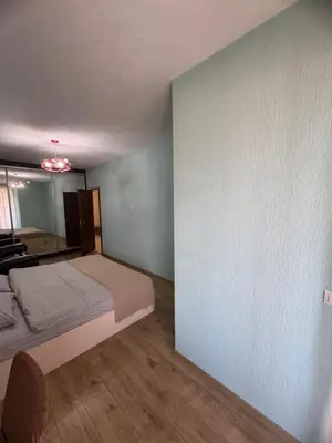 a small bedroom with a bed and a mirror at Луксозен апартамент в сърцето на Сандански in Sandanski