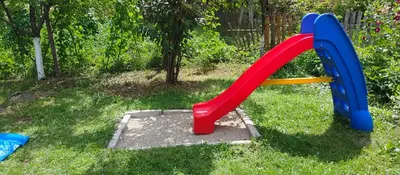a playground with a slide in the grass at Вила Даяна in Ribarica