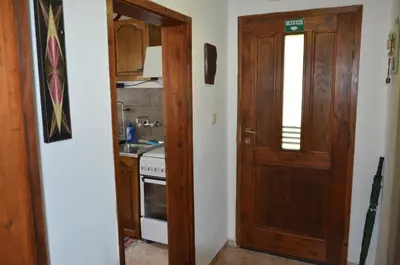 a kitchen with a wooden door and a stove at Вила Даяна in Ribarica