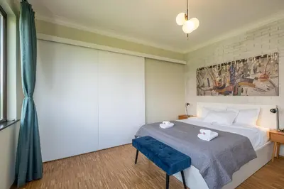 a bedroom with a bed and a blue chair at Sunrise 1BDRM View Apartment NDK Congress Centre in Sofia
