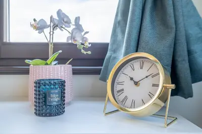 a clock sitting on a table next to a window at Sunrise 1BDRM View Apartment NDK Congress Centre in Sofia
