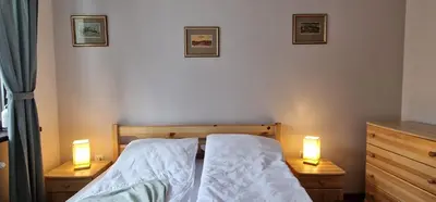 a bedroom with a bed with two lights on it at Pine Tree Apartment / Borovets Gardens in Borovets