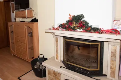 a fireplace with a christmas wreath on top of it at ЗАМЪКА 1 in Pamporovo