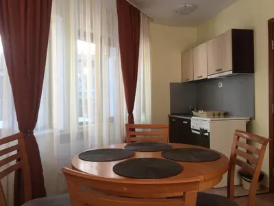 a kitchen with a table with chairs and a small kitchen at ЗАМЪКА 1 in Pamporovo