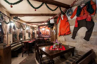 a restaurant with a table and chairs and christmas decorations at ЗАМЪКА 1 in Pamporovo