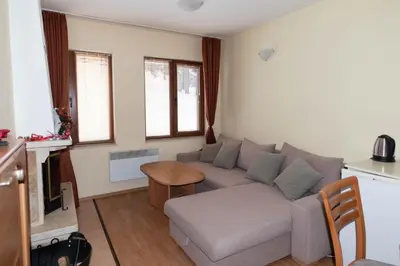 a living room with a couch and a table at ЗАМЪКА 1 in Pamporovo