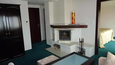 a living room with a fireplace and a couch at Family Hotel Shipkovo in Shipkovo