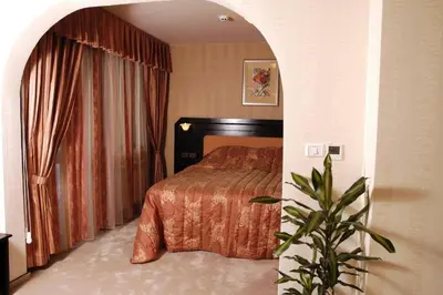 a bedroom with a bed and a potted plant at Family Hotel Shipkovo in Shipkovo