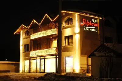 a building with a sign on the side of it at Family Hotel Shipkovo in Shipkovo