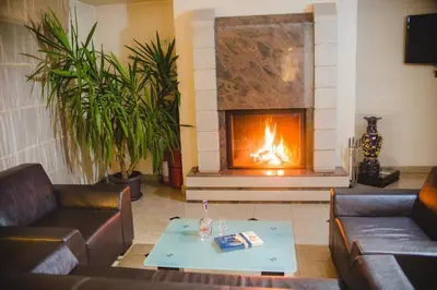 a living room with two couches and a fireplace at Family Hotel Shipkovo in Shipkovo