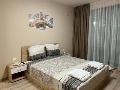 a bedroom with a large bed and a window at Georgievi Apartments Sandanski in Sandanski