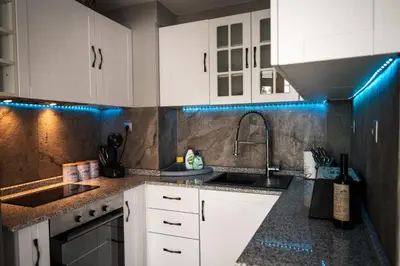 a kitchen with white cabinets and a sink at House Proctor in Stoykite