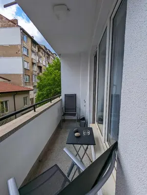 a balcony with a table and chairs on a building at Top Center Relax, NDK & Vitoshka & Metro station in Sofia
