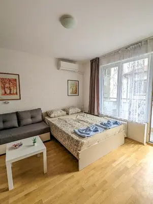 a bedroom with a bed and a couch and a window at Top Center Relax, NDK & Vitoshka & Metro station in Sofia