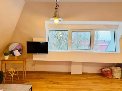a living room with a tv and two windows at Minimalist Apartment in Sofia