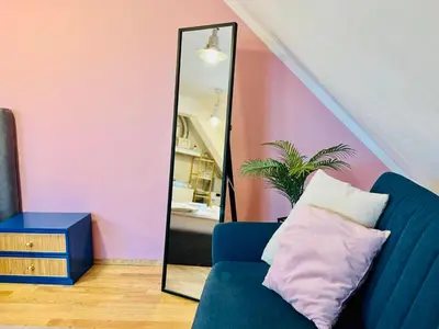 a room with a blue couch and a mirror at Minimalist Apartment in Sofia