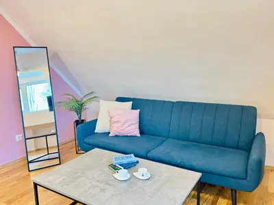 a blue couch in a living room with a coffee table at Minimalist Apartment in Sofia