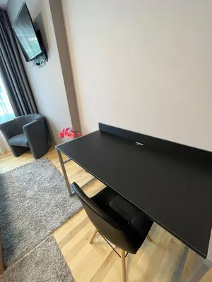 a black desk with a black chair in a room at CityApartment in Sofia