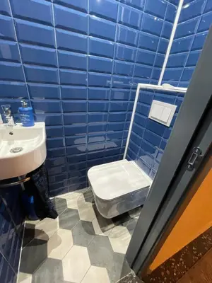 a blue tiled bathroom with a toilet and a sink at The Best Place in the heart of Sofia City center in Sofia