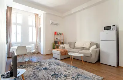 a white living room with a couch and a table at Supreme Luxury Top Central 1 Bedroom Apartment in Sofia