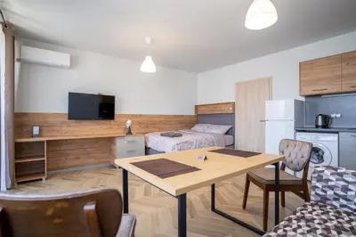 a living room with a table and a kitchen at Amarant Aparts in Sofia