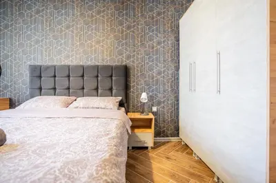 a bedroom with a bed and a wall at Amarant Aparts in Sofia