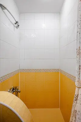 a bathroom with a shower with a yellow tile at Charming Studio on Vitosha Street by Flat Mаnager in Sofia