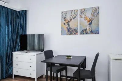 a dining room with a table and a tv at Charming Studio on Vitosha Street by Flat Mаnager in Sofia