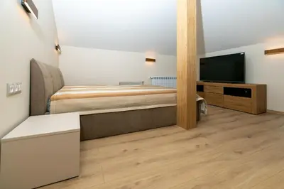 a bedroom with a bed and a flat screen tv at Луксозни студия “Старият Батак” / Luxury studios “The Old Batak” in Batak