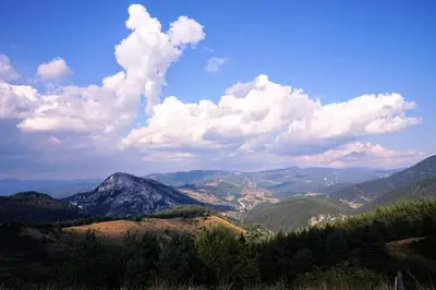 a view of a mountain range with clouds in the sky at Къща Чолаков и син - стаи за гости in Devin