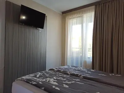 a bedroom with a bed with a television on the wall at Azalia Sandanski in Sandanski