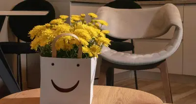 a paper bag filled with yellow flowers on a table at Луксозно студио One Place in Sofia A1 - Лозенец in Sofia