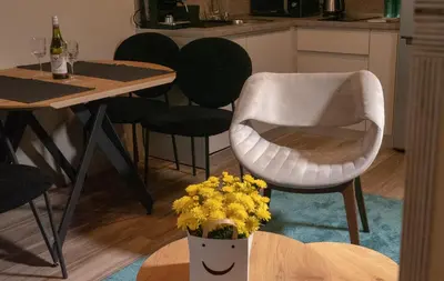 a chair and a table with a vase of yellow flowers at Луксозно студио One Place in Sofia A1 - Лозенец in Sofia