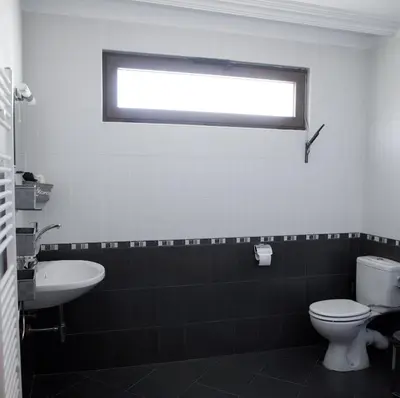 a bathroom with a toilet and a sink and a window at Guesthouse Gaby in Sapareva Banya