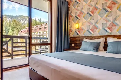 a bedroom with a bed and a large window at Oak Residence Hotel & Relax in Smolyan
