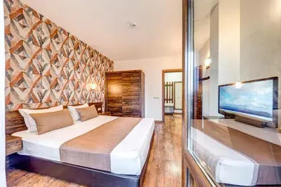 a bedroom with a large bed and a flat screen tv at Oak Residence Hotel & Relax in Smolyan