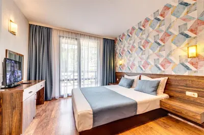 a hotel room with a bed and a large window at Oak Residence Hotel & Relax in Smolyan