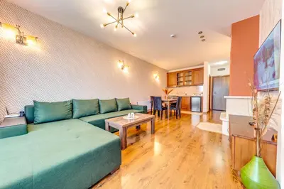 a living room with a blue couch and a table at Oak Residence Hotel & Relax in Smolyan