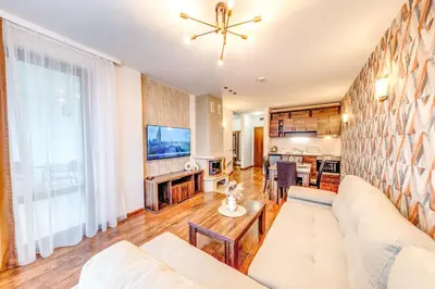 a living room with a white couch and a table at Oak Residence Hotel & Relax in Smolyan