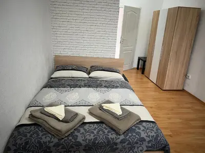 a bedroom with a bed with two pillows on it at Мини Студио Рози in Sandanski